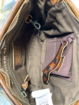 Photo of inside of purse with brown fabric liner with zipper pocket and conceal carry pocket