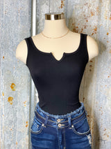 Photo of black bodysuit on mannequin with denim jeans on.