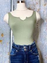 Photo of olive green bodysuit on mannequin with denim jeans on.