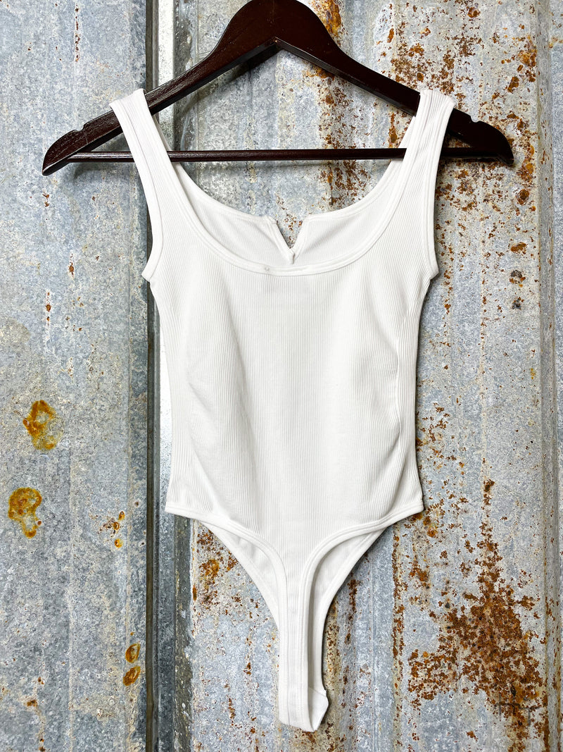 Photo of back view of white bodysuit on clothes hanger
