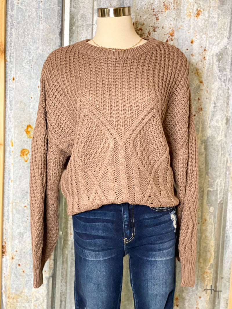 Photo of mocha brown knit sweater on a mannequin with tin background