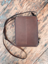 Photo of back side of dark brown leather purse with long crossbody strap